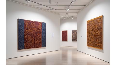 Intricate Indigenous artwork displayed in a contemporary gallery setting, with subtle lighting highlighting its details.